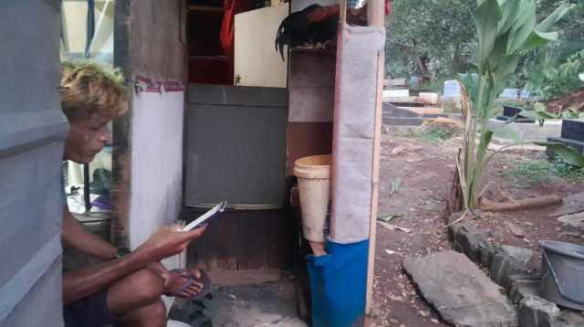 Tampak IS tengah meratapi nasib di area Pemakaman. Hidupnya terpuruk akibat keranjingan Judi Online dan terlilit hutang pinjol. (Foto : iNewsBogor.id/Martin)