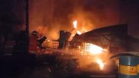 petugas-damkar-saat-memadamkan-kebakaran-gudang-bbm-ilegal-di-jambi_169